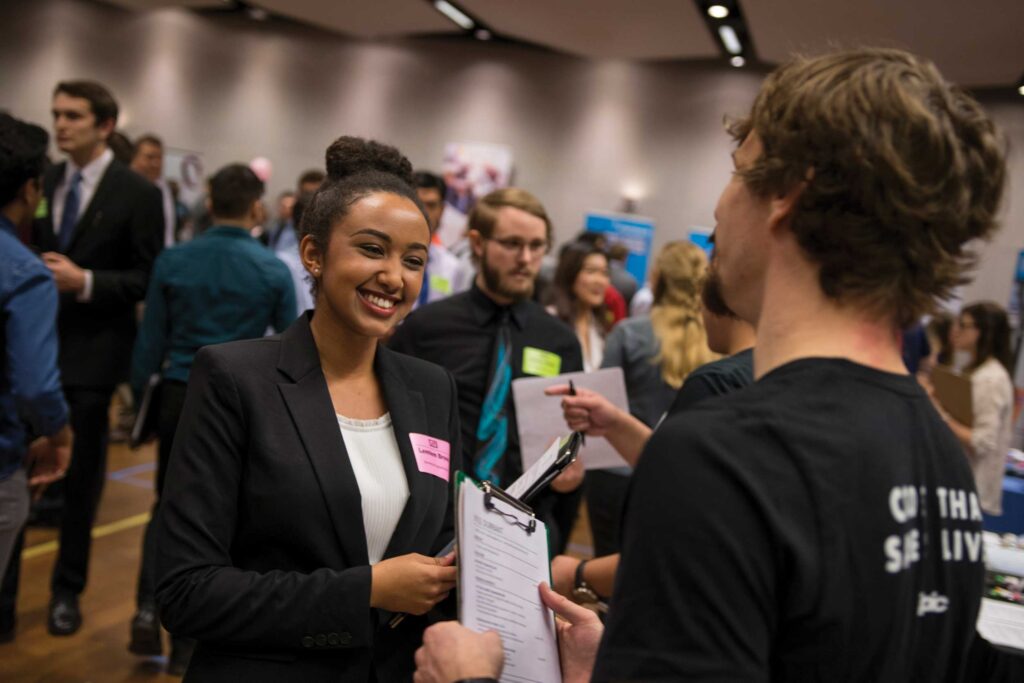 A student talks with a recruiter at a job fair.