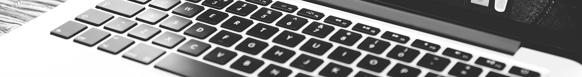 Black and white photo of the keyboard for a MacBook Pro laptop.