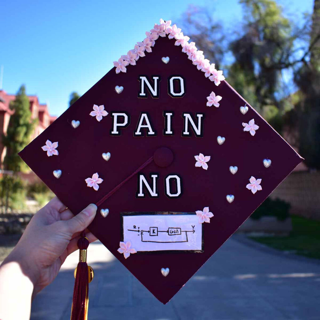 Mortarboard decorations by Marissa Edwards, mechanical engineering BSE, that say No Pain No Gain.