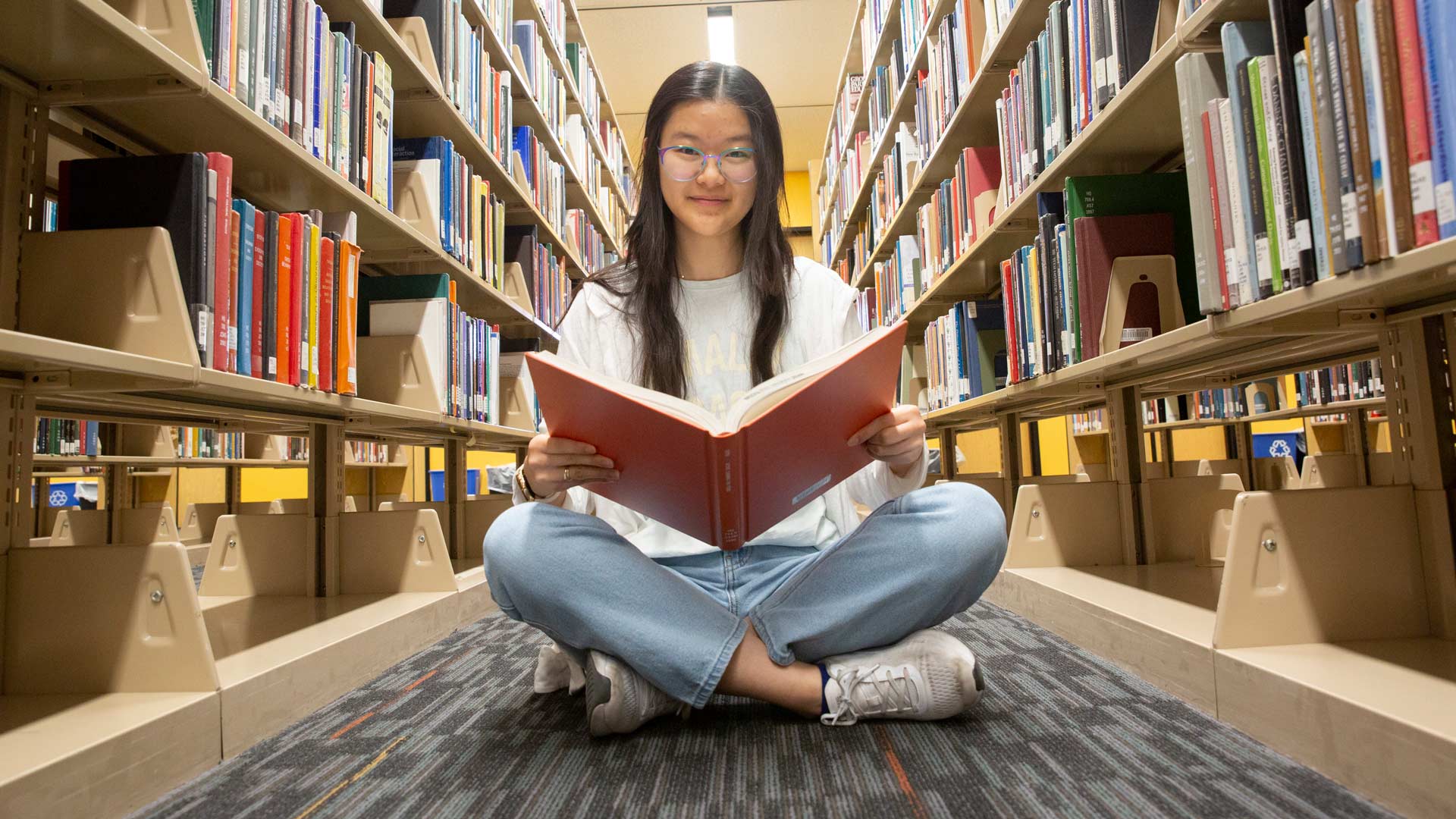 A student reads a book in the library