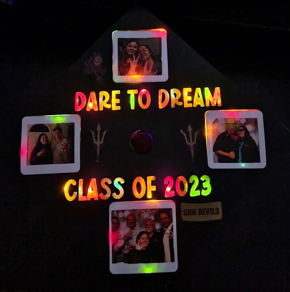 A mortarboard with lights and photos that says "Dare to Dream Class of 2023."
