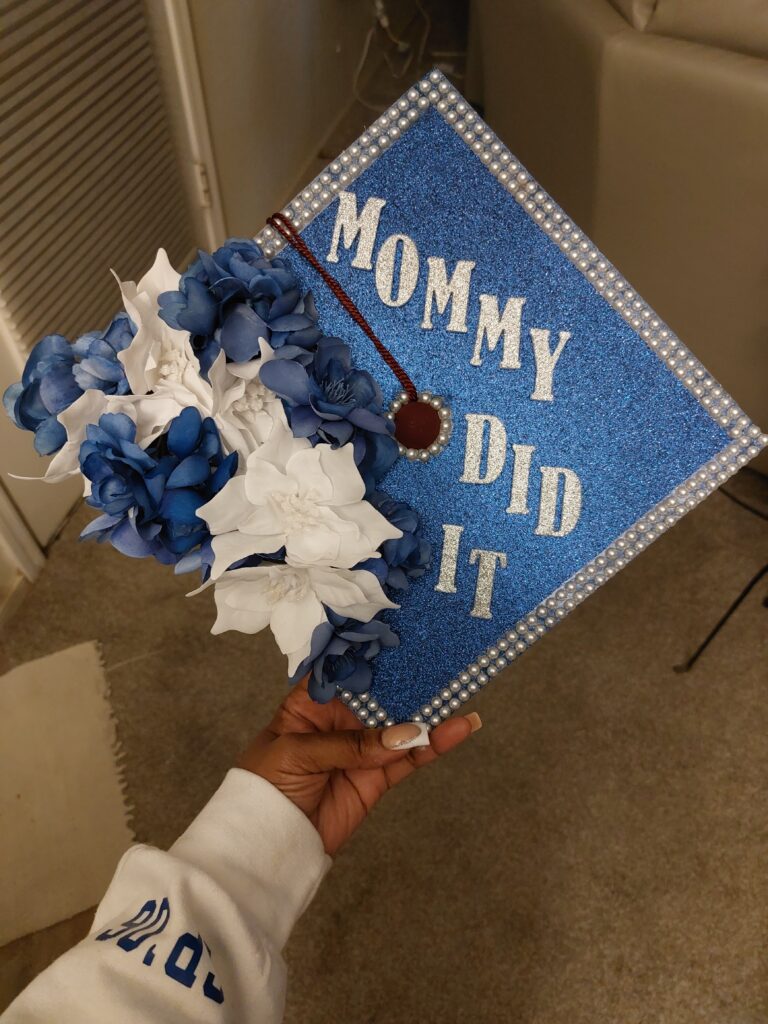 A decorated mortarboard with flowers and the words "Mommy did it."
