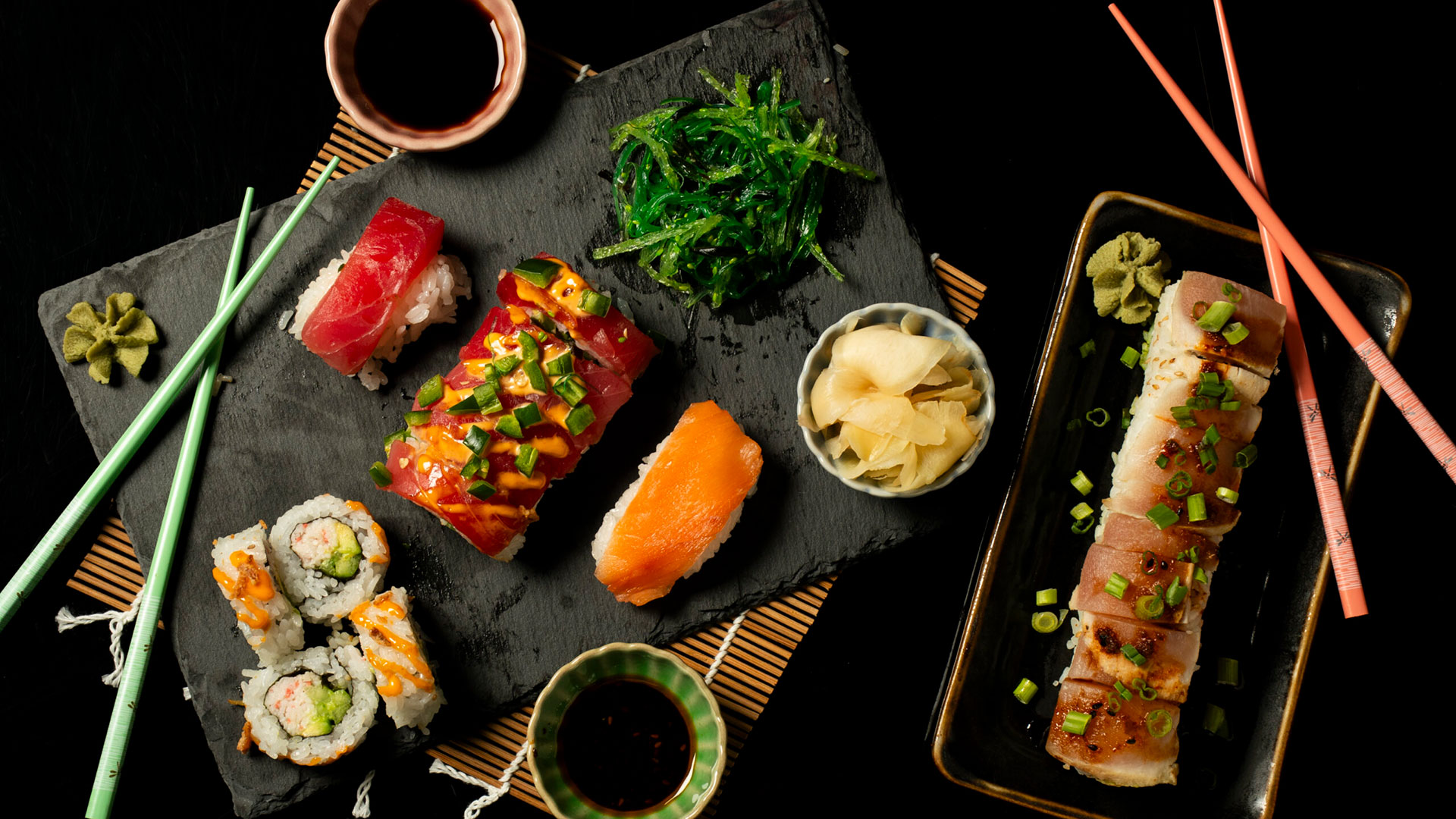 sushi placed nicely on a platter with sauce and chopsticks