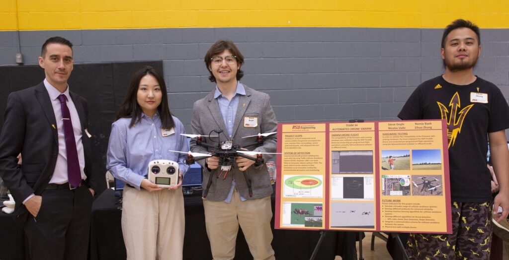 Students standing in front of a poster presenting group project