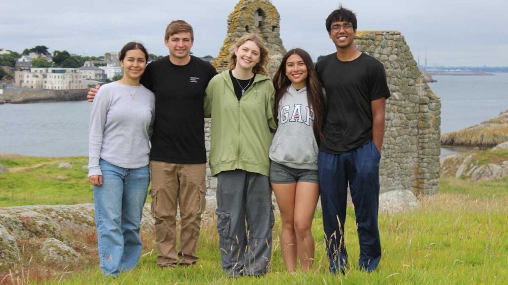 A group of students lined up in front of an Irish vista.