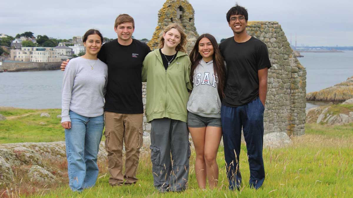 A group of students lined up in front of an Irish vista.